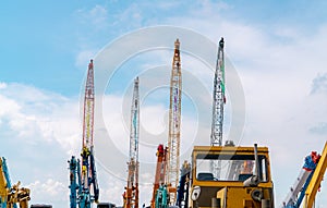 Crane against blue sky and white clouds. Real estate industry. Red and yellow crawler cranes use reel lift-up equipment. Crane for
