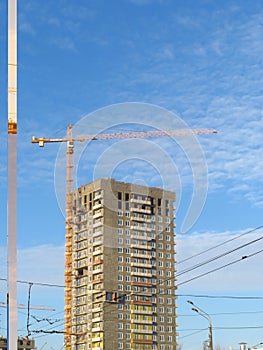 Crane on the background of beautiful blue sky with clouds.