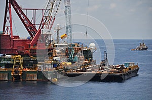 Crane barge lifting heavy cargo or heavy lift in offshore oil and gas industry. Large boat working for lift piping