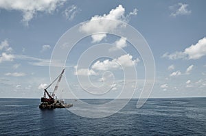 Crane barge lifting heavy cargo or heavy lift in offshore oil and gas industry. Large boat working for lift piping