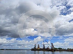 crane barge on the river against the background of blue sky and clouds 3