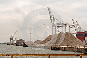 A crane, barges, warehouse and ballast at the Port of Southampton in Hampshire, UK