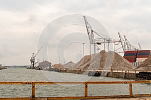 A crane, barges, warehouse and ballast at the Port of Southampton in Hampshire, UK