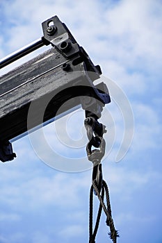 Crane boom with isolated hook  blue sky background Elements of crane: hook  loop  chain  connecting parts