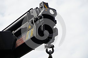 Crane boom with isolated hook, blue sky background,Elements of crane: hook, loop, chain, connecting parts