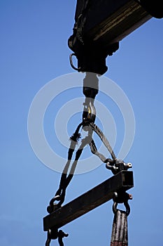 Crane boom with isolated hook, blue sky background,Elements of crane: hook, loop, chain, connecting parts