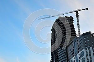 Crane and building construction site against blue sky