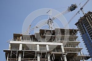 Crane and building construction site against the blue sky