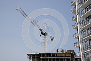 Crane and building construction site against blue sky