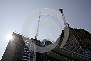 Crane and building construction site against blue sky