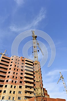 Crane and building construction site against blue sky