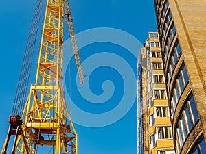 Crane and building construction site against blue sky