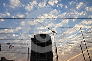 Crane and building construction site against blue sky