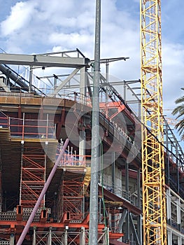 Crane and building construction site against cloudy sky