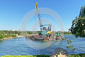 Crane building construction site house on river in sunny summer day