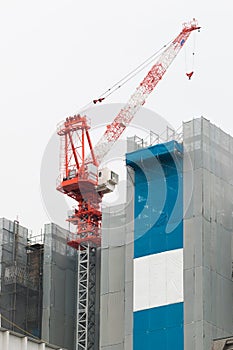 Crane and building construction site with white background.