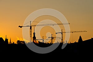 Crane and building silhouettes over sun at sunrise