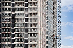Crane and building under construction against blue sky.
