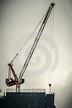 Crane and building under construction. A building site with Industrial construction crane on the top