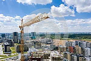 Crane and buildings under construction against blue sky background. aerial photo