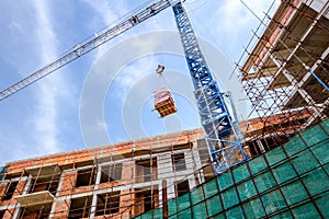 Crane is carry pile red blocks packed in plastic foil