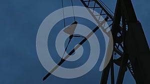 A crane at a construction site lifts a steel beam.