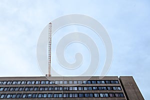 Crane on a construction site over a 70`s office building of socialist style currently in renovation in city center of Budapest