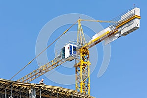 Crane on construction site over blue sky