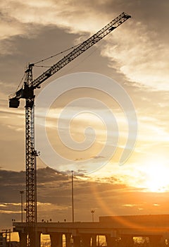 Crane at construction site and sunset sky
