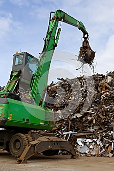 A crane grabber loading a metal