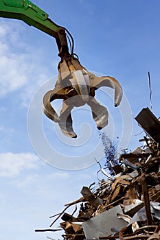 A crane grabber loading a metal