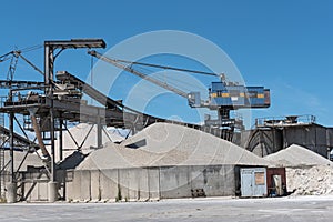 A crane with gravel in a gravel pit and different types of stone