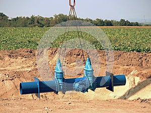 Crane handling 500mm pipe with gate valves. Construction process