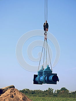 Crane handling 500mm pipe with gate valves. Construction process