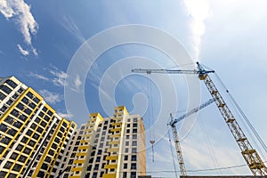 Crane and high rise building under construction against blue sky
