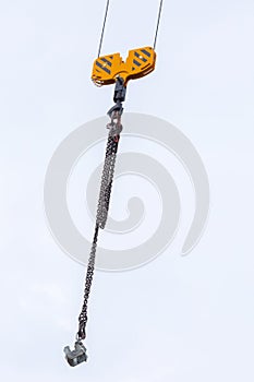 Crane hoisting block with hook on steel chain on the steel rope. Loading\unloading of building materials on construction building