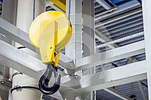Crane hook inside factory building, industrial background