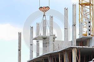 Crane hook raises large concrete panel for construction