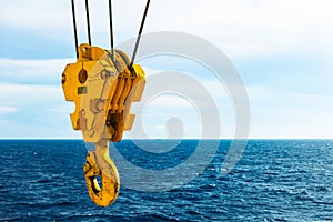 Crane hook in the sea with sky and clouds background on offshore