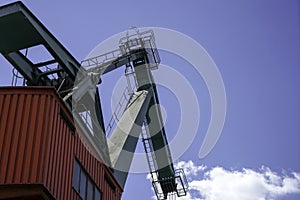 Crane for industrial handling of goods in the port with blue sky in the back