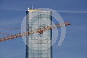 Crane jib against building and blue sky