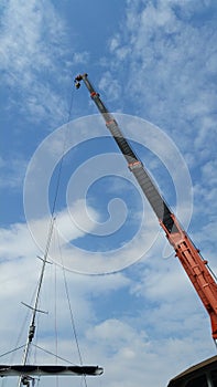 Crane lift up the mast put the mast in to boat