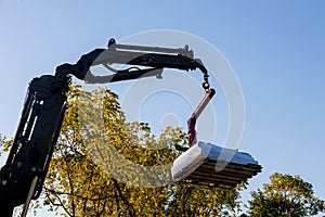 A crane lifting building materials to home roof