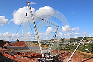 Crane lifting a concrete bridge beam