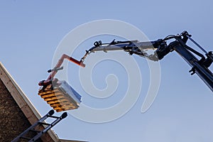 Crane lifting materials roofing construction at work