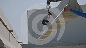 Crane lifting a part of a concrete wall at a construction site