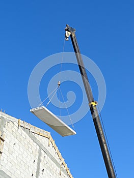 Crane lifting a part of a roof