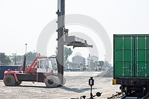 Crane lifting up container in yard