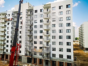 a crane lifts building materials for builders of new houses from monolithic reinforced concrete. Construction of