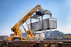 Crane lifts a container loading a train